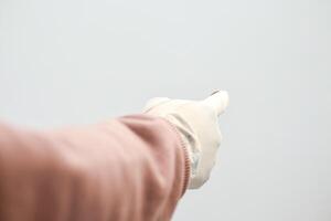 Hand in white glove pointing on a white background, indicating a direction or selection with outstretched arm photo