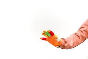 A hand wearing a colorful glove extending outwards against a white backdrop, showcasing playful creativity and vibrancy photo