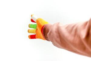 Hand wearing colorful touch screen gloves on a white background in studio shot photo