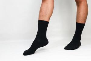 Close-up shot of a man's legs wearing black socks against a plain white background, showcasing fashion and comfort photo