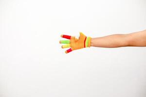 Hand with colorful finger glove on white background, showcasing playful fashion and creative expression against clean backdrop photo