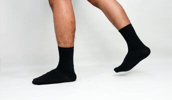 Studio shot showcasing a man walking while wearing comfortable black socks on a white background photo