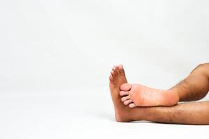 Close-up of Man's Bare Feet Relaxing on a White Background Showing Skin and Toes with Copy Space photo