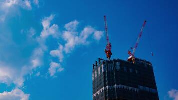 A timelapse of cranes at the under construction behind the blue sky in Tokyo video