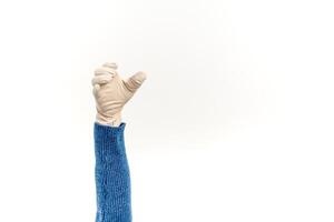Isolated hand wearing medical glove and blue sweater showing grabbing gesture on white background photo
