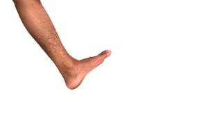 Isolated lower leg of a person with brown skin tone kicking in the air, studio shot on a white background with space for text photo