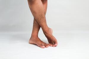 A Pair of Crossed Legs and Bare Feet on a White Background Evoking Relaxation and Elegance photo