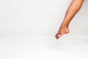 Studio shot of a person's leg, emphasizing foot dexterity and anatomy with a white background photo