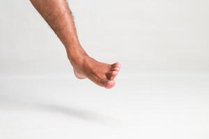 Isolated foot and leg of a man dangling with white background, showing a unique perspective of human anatomy and movement photo