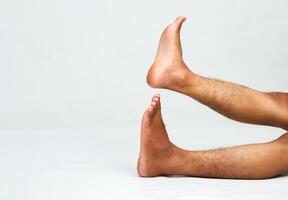Conceptual image of human legs with feet raised against a plain white backdrop photo