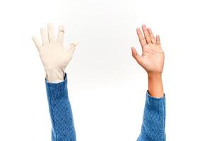 A gloved hand versus a bare hand on a white background photo