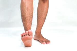 Close-up of Man's Legs and Feet on White Background Showcasing Skin Tone and Texture with Light and Shadow Play photo