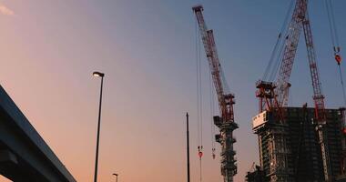 Cranes at the under construction in Tokyo wide shot at dusk video