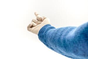 Person wearing a blue sweater and latex glove pointing up on a white background photo