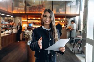 woman smiling in cafe with paperwork photo