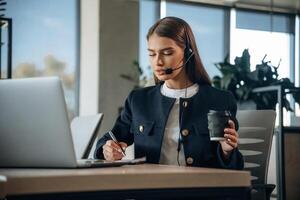 Call center, in headphones. Woman is working in the office photo
