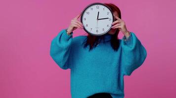Young woman holding clock watch, hiding, checking time on clock, running late to work being in delay video