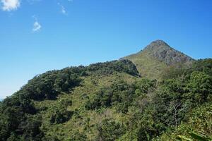 Landscape of stone green mountain range with cloudy blue sky photo