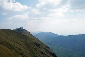 Rainforest summit ridge and green hill range with cloudy blue sky photo
