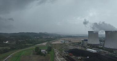 Aerial drone footage of a large coal power plant station with cooling towers chimney and boiler house in an air pollution or carbon footprint concept video