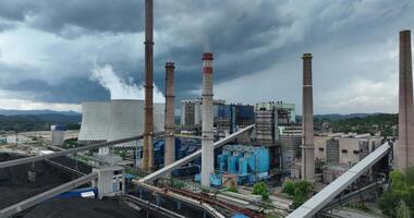 Aerial drone footage of a large coal power plant station with cooling towers chimney and boiler house in an air pollution or carbon footprint concept video