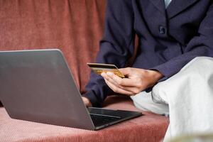 Close-up of a person using a laptop and credit card for online shopping, highlighting e-commerce and digital transactions. photo
