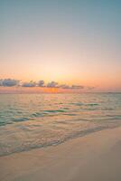 Sunset beach closeup vertical view showing calm sea, soft sand, and warm colorful sky, tranquil tropical nature scene inspiring peaceful vacation, travel, and serene beach moments photo