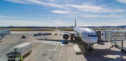 Airplane on runway in front of modern terminal preparing for takeoff, transportation background for air travel, tourism, vacation, business trip, international flight scene photo