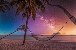 Stunning milky way night sky over hammock hanging between palm trees on tropical beach, serene peaceful vacation getaway, tranquil nature scene, starry sky tropical island paradise, outdoor relaxation photo