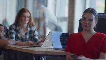A diverse group of colleagues collaborates using laptops, mobiles, and tablets to tackle business challenges and enhance productivity through teamwork and innovative technology. video