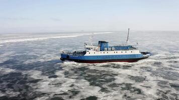 A ferry among ice floes on a sunny day in winter from a drone video
