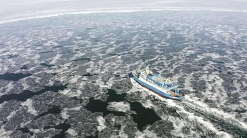 A ferry among ice floes on a sunny day in winter from a drone video