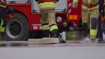 A special team of firefighters seizes hoses from a firetruck and embarks on a perilous mission to extinguish a blazing fire, showcasing their bravery and professional expertise in tackling a hazardous video