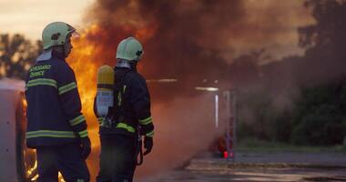 Firefighters fight the fire flame to control fire not to spreading out. Firefighter industrial and public safety concept. Traffic or car accident rescue and help action. video