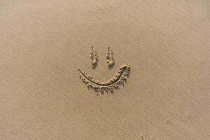 Smile Drawn On Sand Textured Background photo