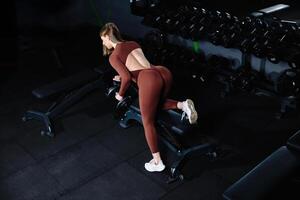 Female athlete lifting dumbbell during workout in gym. photo