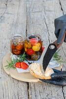 Chef spreading marinated cheese on toasted bread with cherry tomatoes and rosemary photo