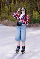 Young woman roller skating in a park during spring enjoying a sunny day. photo