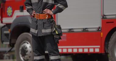 A special firefighter stands beside a firetruck, poised and ready for a high-risk rescue mission in dangerous fire scenarios, exemplifying unwavering dedication to saving lives in emergency video