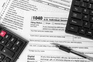 Filing taxes online with 1040 form, calculator, pen, and keyboard. Concept of electronic tax return before the deadline. photo