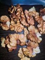 A detailed close-up of the walnut kernel elegantly exposes its interior, showcasing the freshly revealed, nutrient-rich core alongside its distinctive texture. photo