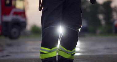 Portrait of a heroic fireman in a protective suit. Firefighter in fire fighting or car accident rescue operation in dusk or night. video