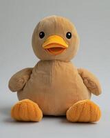 A stuffed duck sitting on a white surface photo