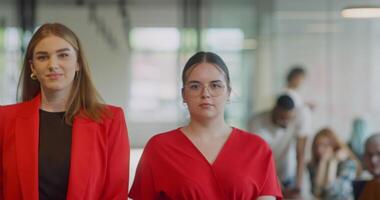 Team of confident businesswomen striding through the hallways of a modern startup space, showcasing their self-assured determination with crossed arms as they convey their dedication to work video