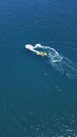 Aerial drone top view tracking of yellow speed boat cruising and having fun while making curves in high speed deep video