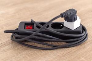 An electrical extension cord socket on wooden table photo
