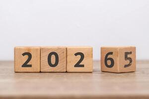Wooden block with 2025 change to 2026 with the number five already faded. Turn of the new year. New year's resolution. photo