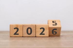 Turn of the new year. Wooden blocks with 2025 change to 2026 with the number five already faded. photo