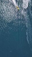 Aerial drone top view tracking of yellow speed boat cruising and having fun while making curves in high speed deep video