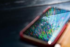 Rainbow blur reflection in glossy surface of smartphone photo